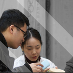 laTD 2016 2 people looking at an object. they are in colour while the background is in black and white