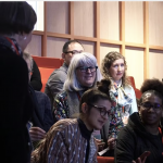 Screenshot-2024-09-23-at-12.39.22 Attendees discussing something in a lecture theatre