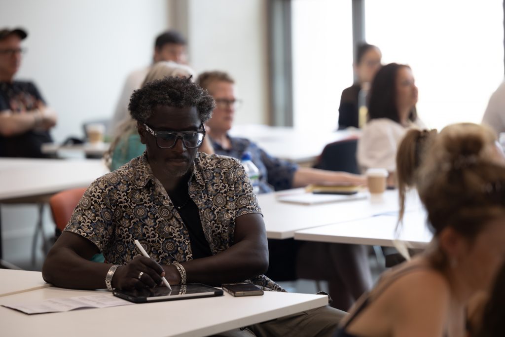 attendee to a session taking notes on an ipage